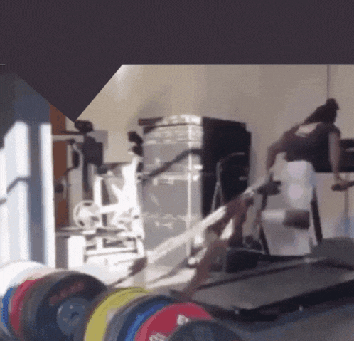 a blurred image of a gym with a treadmill and dumbbells including one that says ' gs '