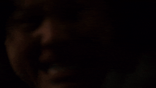 a close up of a man 's face in a dark room