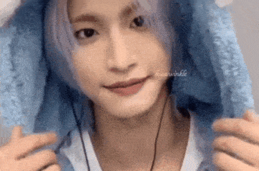 a close up of a person wearing headphones and a blue sweater