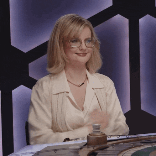 a blonde woman wearing glasses and a necklace that says ' amanda ' on it