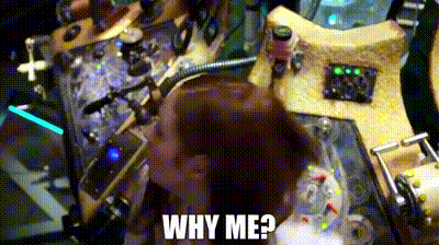 a woman is standing in front of a machine with the words why me written on it