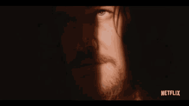 a close up of a man 's face with a netflix logo behind him