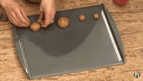 a person is rolling cookie dough on a pan
