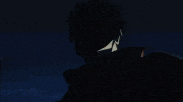 a person is holding a shark with their mouth open in a dark room .