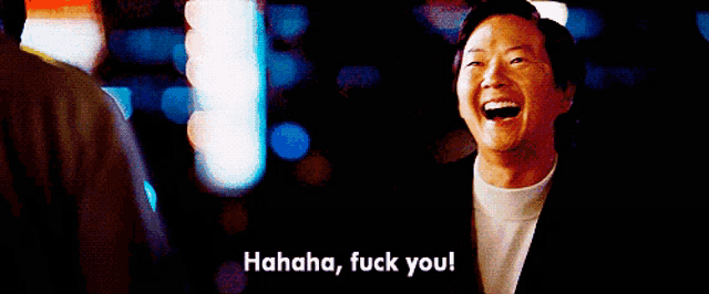 a man in a suit is laughing and says " hahaha fuck you "