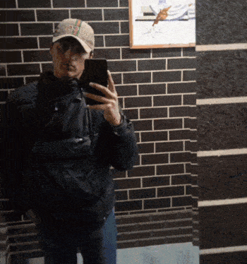 a man wearing a gucci hat takes a picture of himself