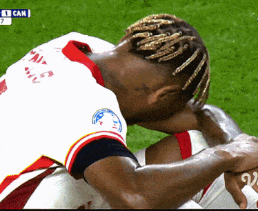 a soccer player with dreadlocks is kneeling down with the number 7 on the screen