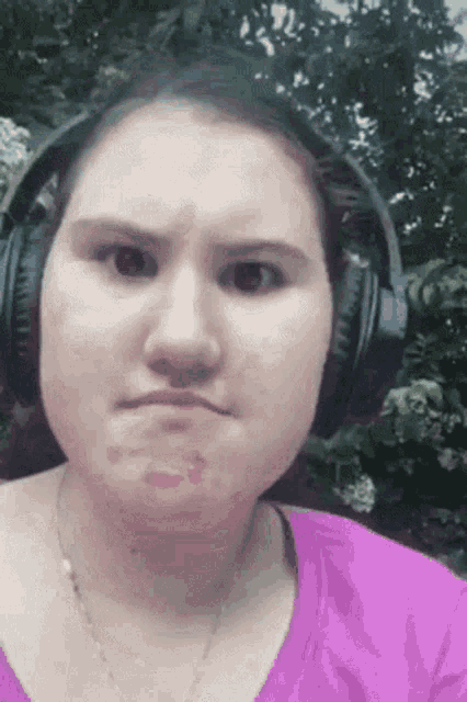 a woman wearing headphones is making a face .