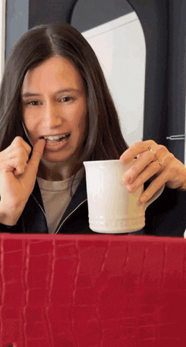 a woman is holding a cup of coffee in her hand