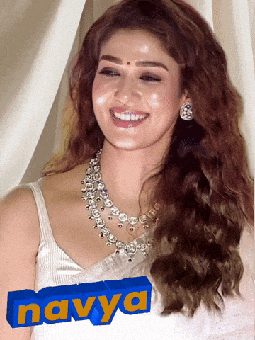a woman wearing a white top and a necklace with the name navya on it