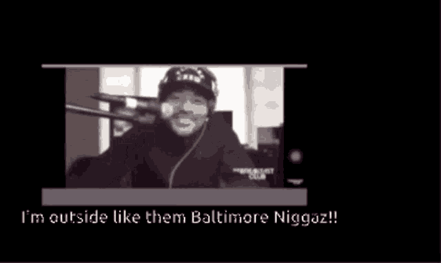 a video of a man talking into a microphone with the words i 'm outside like them baltimore niggaz