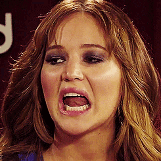 a close up of a woman making a funny face with her mouth open