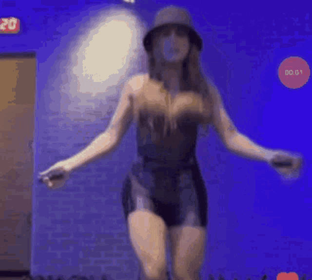 a woman is jumping a jump rope while wearing a hat .