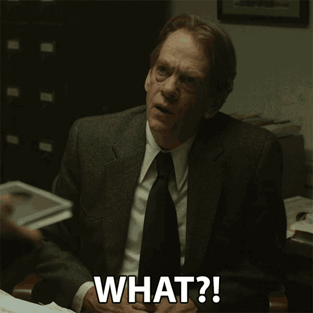 a man in a suit and tie is asking what