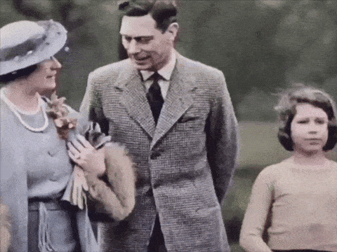 a man in a suit and tie is standing next to a woman in a hat and a girl in a tan shirt .