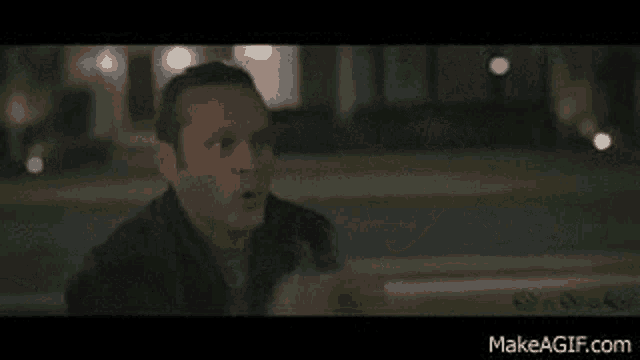 a man is standing in front of a house at night and talking to someone .