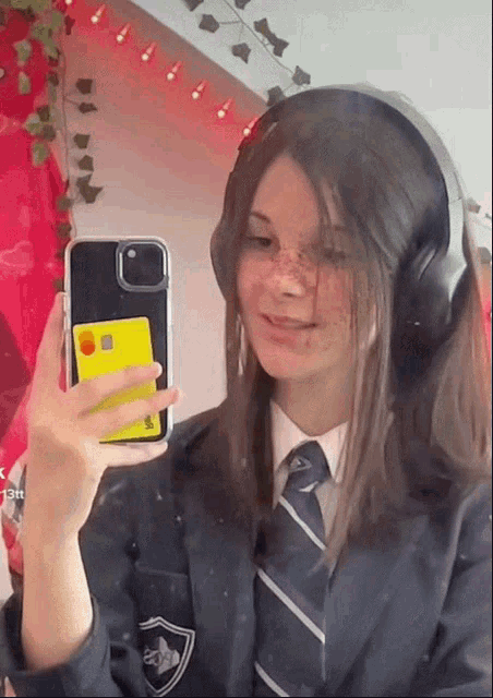 a girl in a suit and tie is taking a selfie
