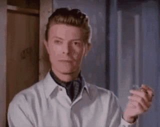 a man in a white shirt and tie is holding a lighter in his hand .