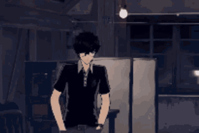 a man in a black shirt is standing in a dark room with his hands in his pockets .