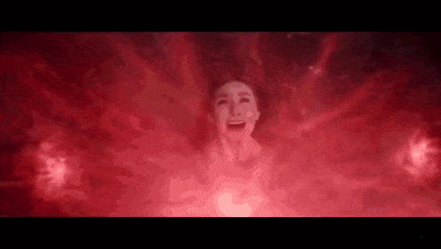 a woman is screaming in a dark room surrounded by red light .