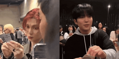 a man with red hair is talking to another man in a crowd of people