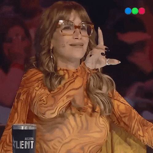 a woman wearing glasses and a tiger print shirt stands in front of a argentina klent cup