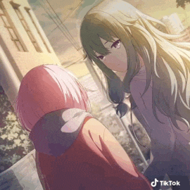 a couple of anime girls are standing next to each other on a sidewalk .