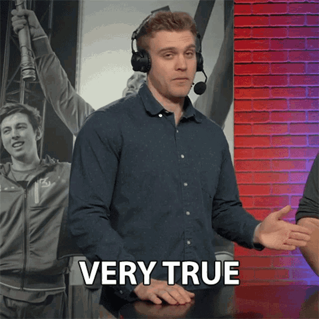 a man wearing headphones stands in front of a sign that says very true