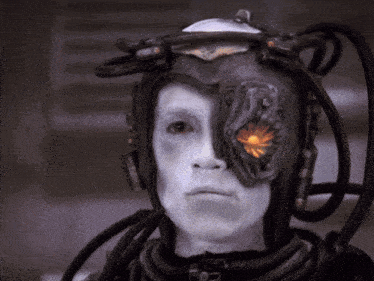 a man with white paint on his face is wearing a helmet with wires coming out of it