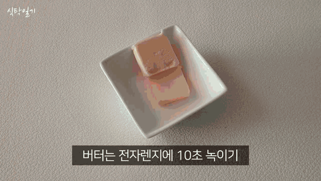 a person pouring sauce into a white bowl with korean writing
