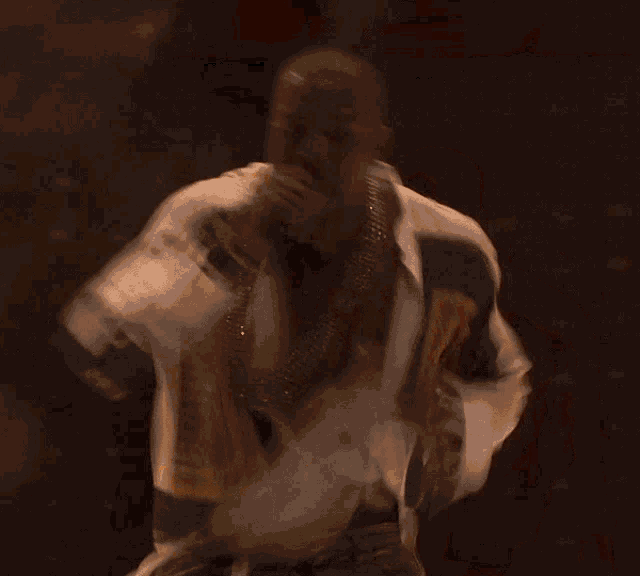 a man singing into a microphone with a red curtain in the background