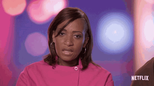 a woman in a pink jacket with a netflix logo on the bottom