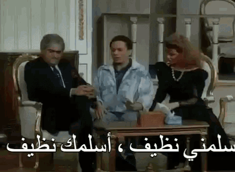 a man and a woman are sitting at a table with arabic writing on it .