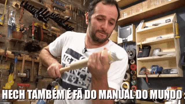 a man is holding a hammer in a workshop with the words hech também e fa do manual do mundo below him