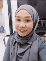a woman wearing a hijab and a scarf is smiling