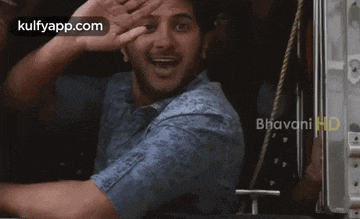 a man is waving his hand out of a train window
