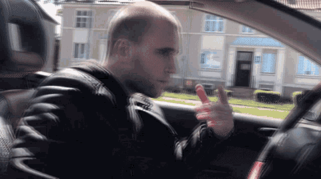 a man in a car giving a thumbs up