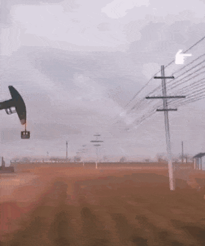 an oil pump is in the middle of a field surrounded by power lines .