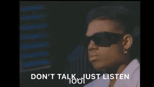 a woman wearing sunglasses is sitting in front of a window and says `` do n't talk just listen '' .