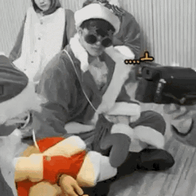 a man in a santa claus costume is sitting on the floor .