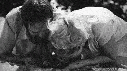 a black and white photo of a man and a woman eating food .