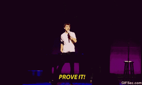 a man in a white shirt stands on a stage with his arm in the air and the words prove it behind him