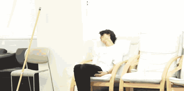 a man in a white shirt is sitting in a white chair