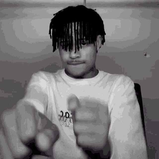 a black and white photo of a young man wearing a white shirt with the number 30 on the front
