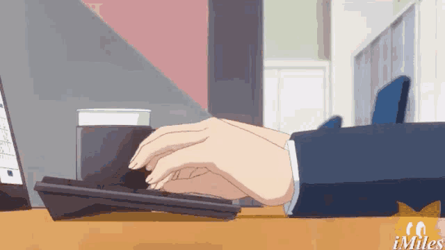 a person is typing on a keyboard with a cup of coffee on the desk .