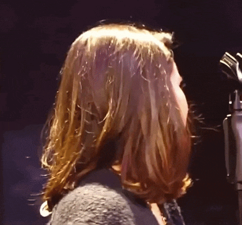 a close up of a woman singing into a microphone .