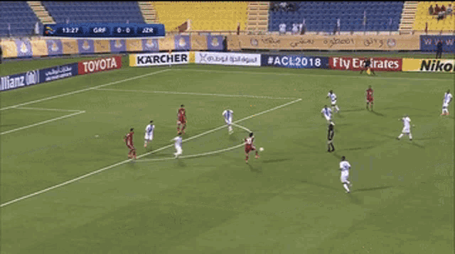 a soccer game is being played in a stadium with ads for fly emirates allianz and toyota