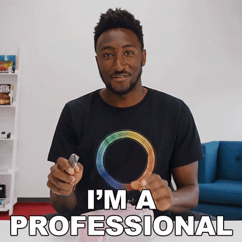 a man wearing a black t-shirt with a rainbow circle on it says i 'm a professional