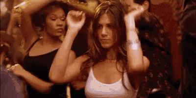 a woman in a white tank top is dancing at a party .