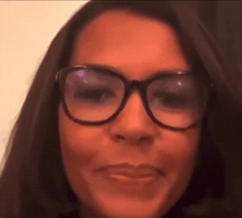 a close up of a woman wearing glasses making a funny face